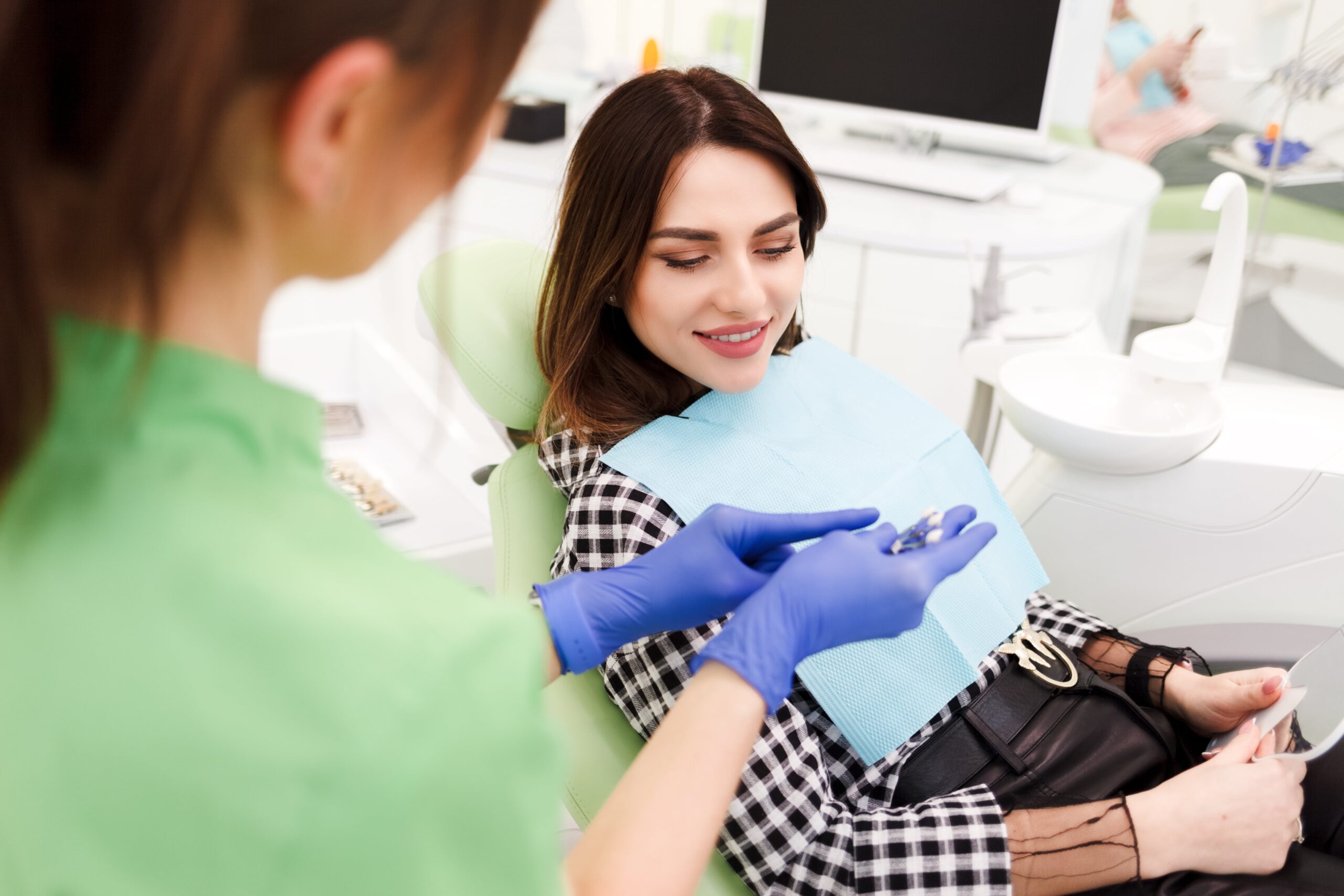 Dentist shows crown samples to his patient.