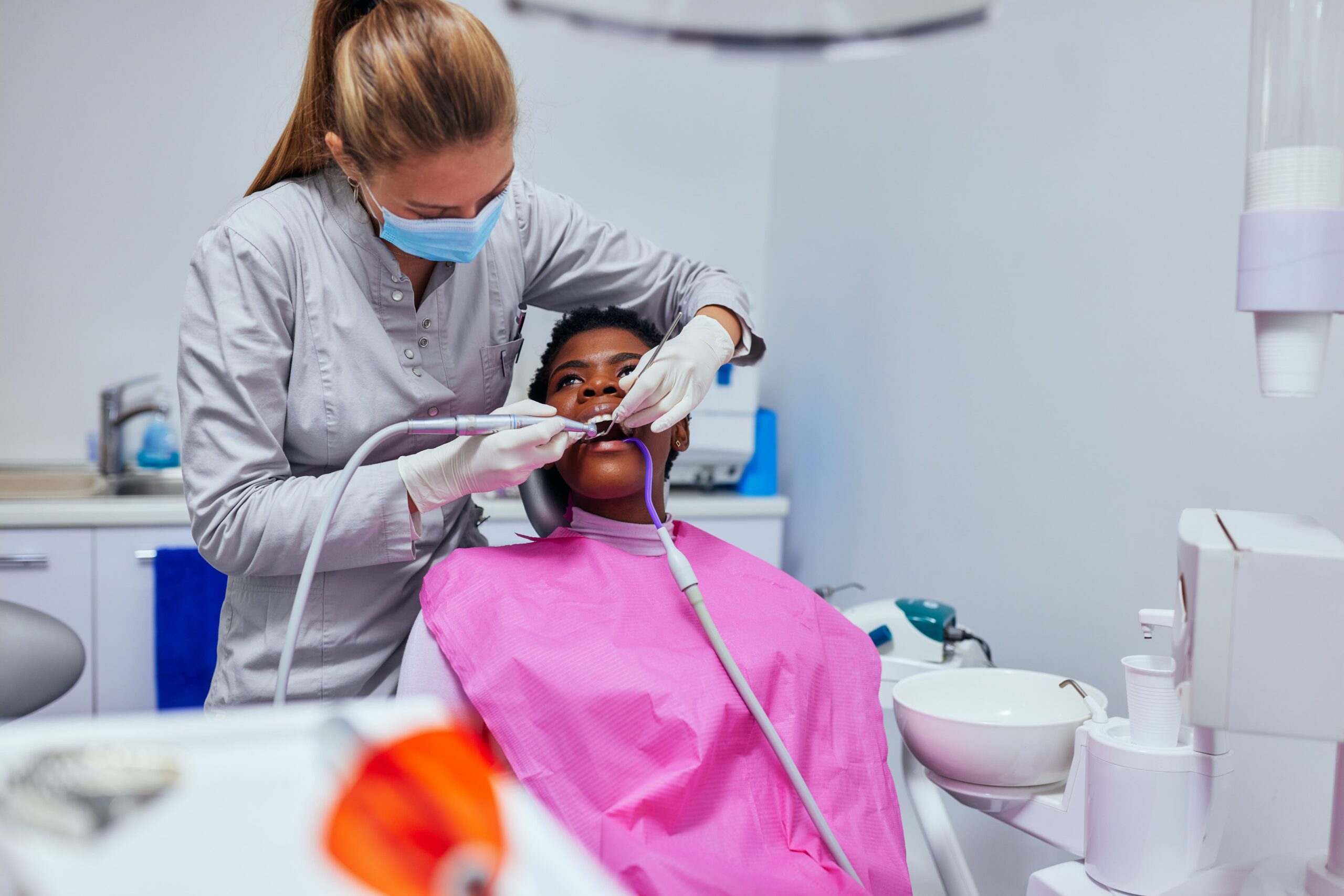 African woman at the dentist fixes teeth.