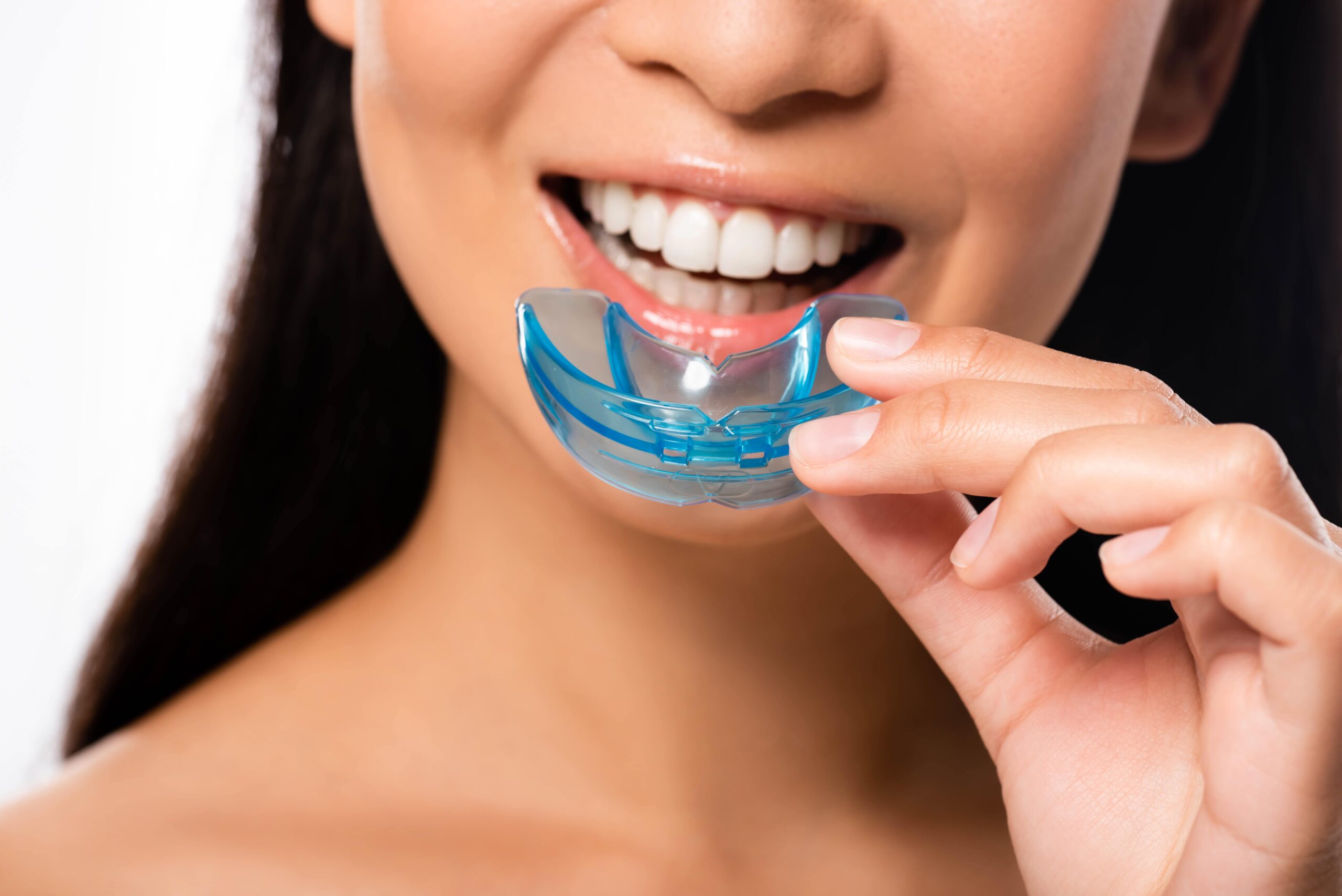Woman holding a mouthguard.