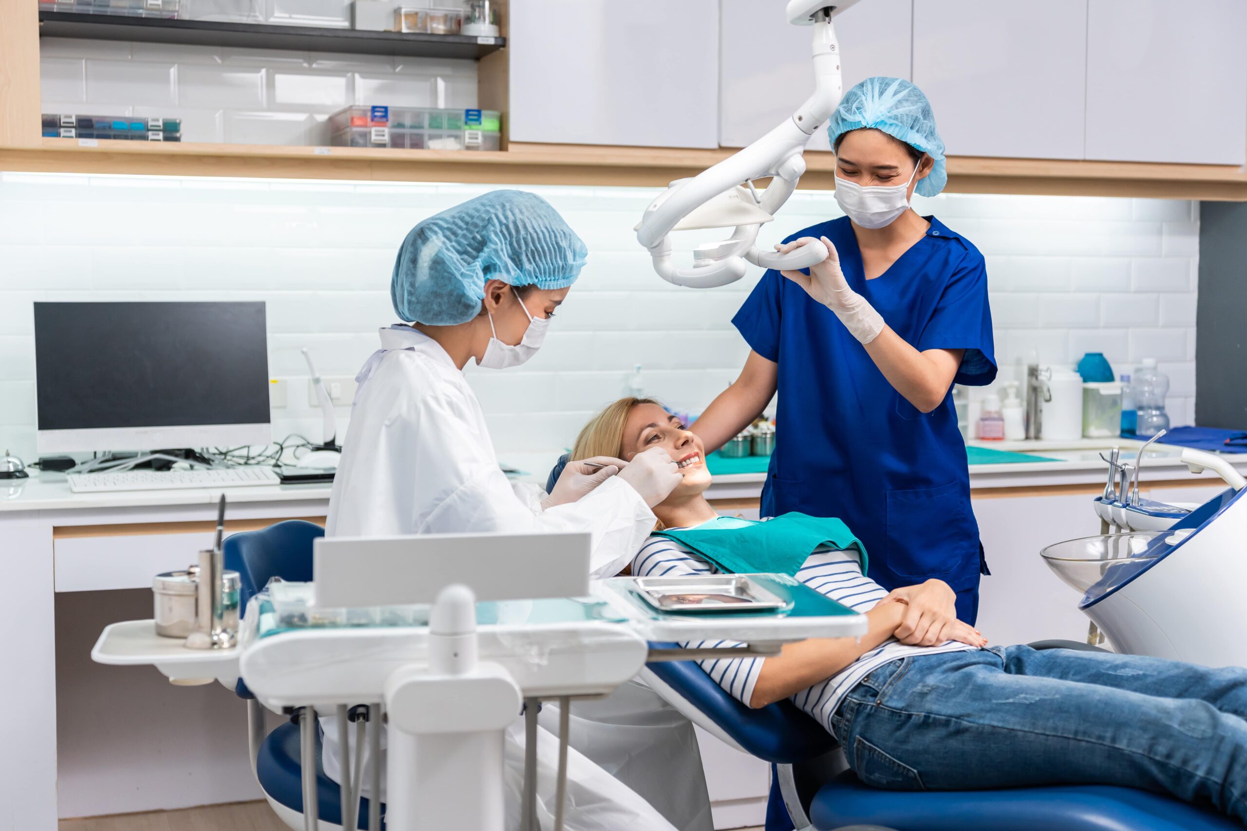 Female dentist examine tooth to Caucasian girl at dental health clinic.