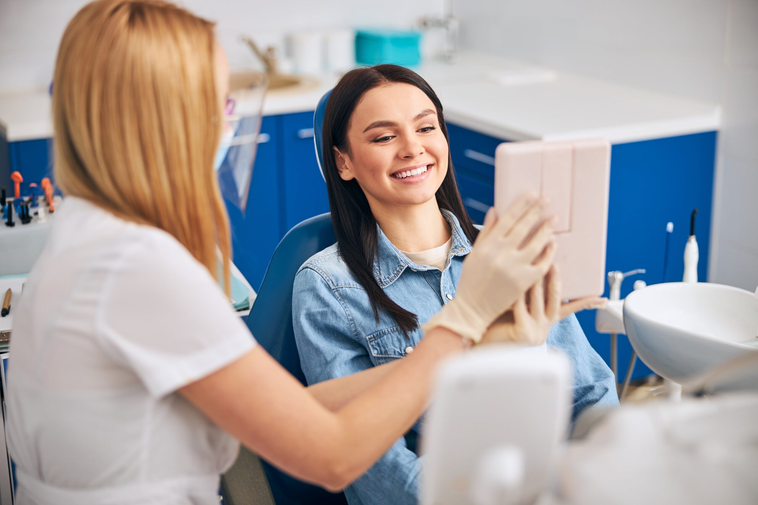 Joyful female person looking at her happy reflection