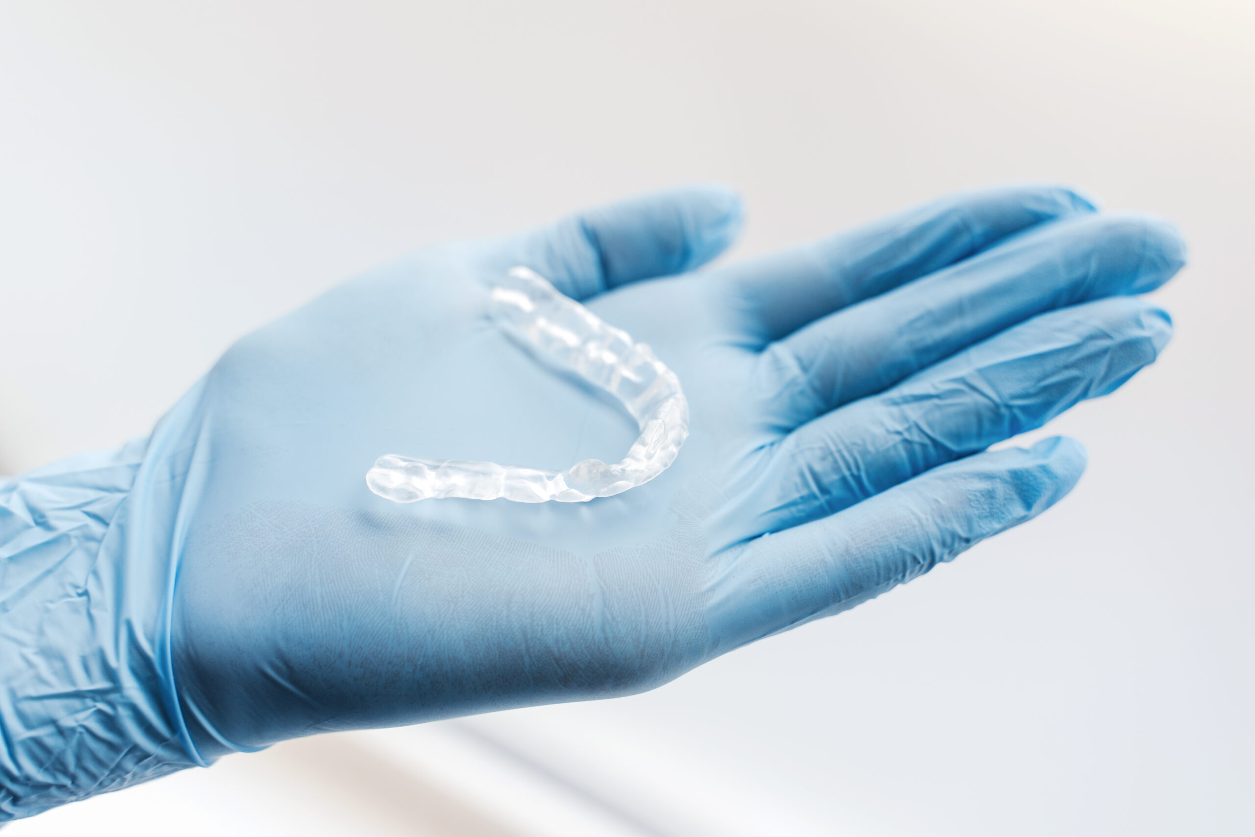 Person holding a clear aligner.