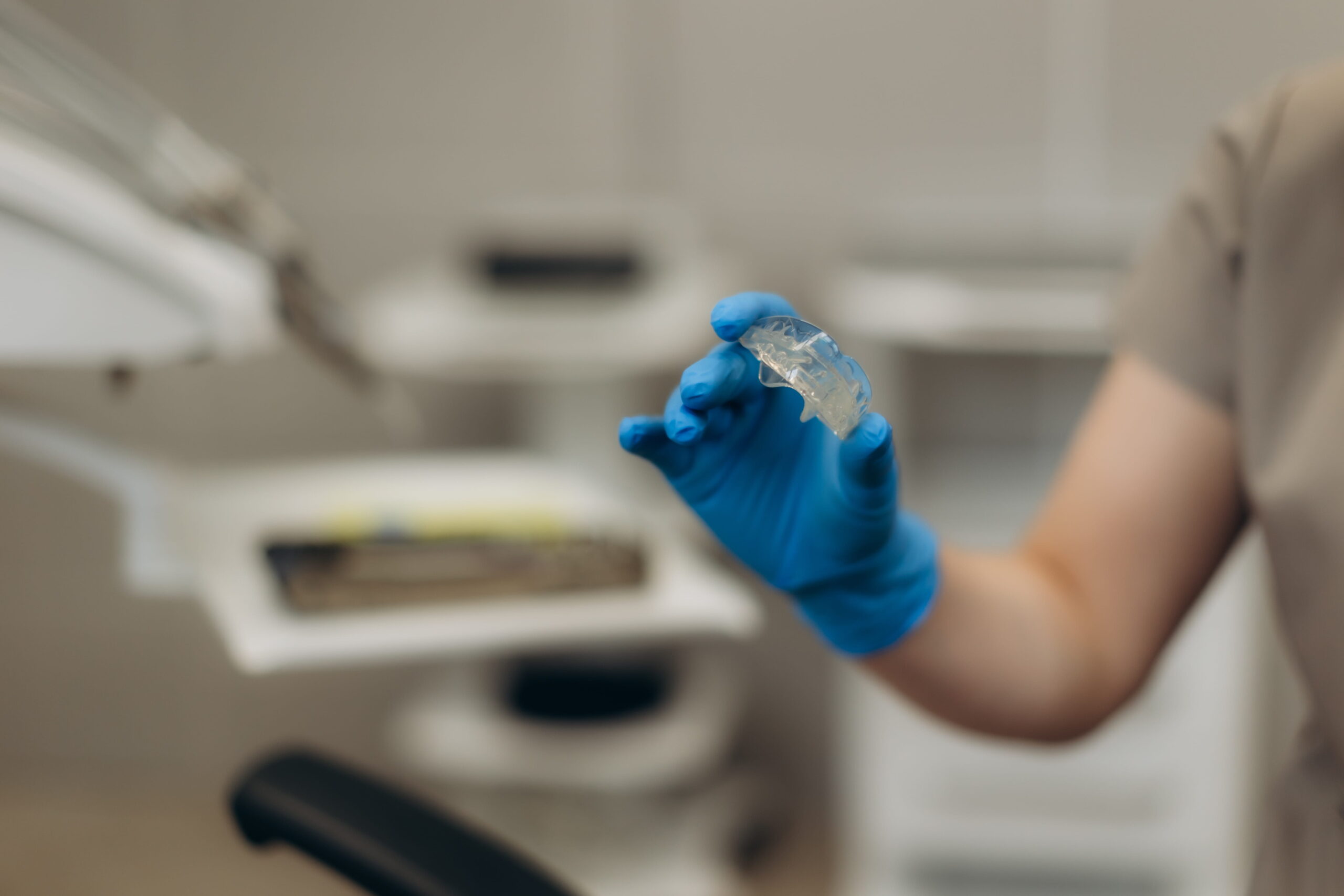 Dentist holding teeth whitening gel tray in dental clinic